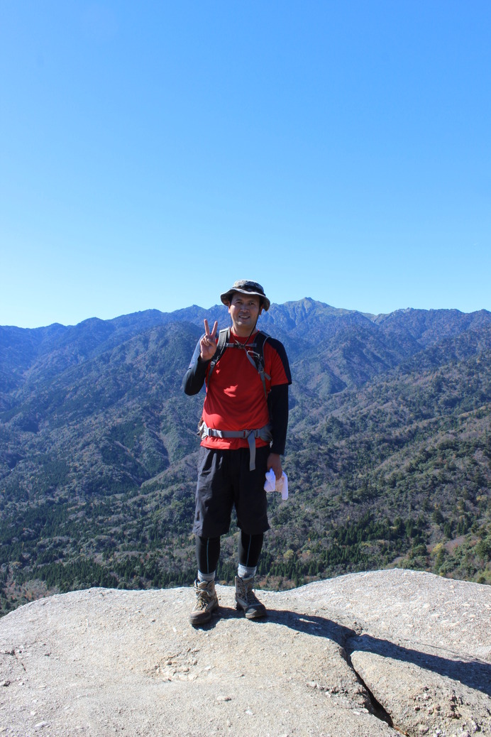 屋久島・太鼓岩登頂時の筆者。11月の屋久島とはいえ、登っていると大汗をかくので、このような服装に。