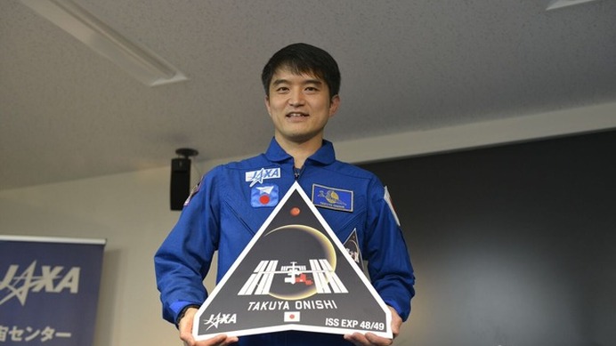 初公開された自身のミッションロゴを手に持つ大西宇宙飛行士