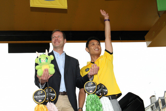 ツール・ド・フランス第3ステージのスタート地点で、さいたま市役所スポーツイベント課の清水大樹主任がクリスティアン・プリュドムに千羽鶴を贈呈した