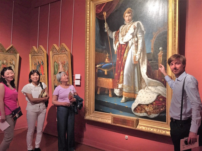コルシカ美術館（アジャクシオ）にあるナポレオンの肖像画を前に日本人観光客をガイドする