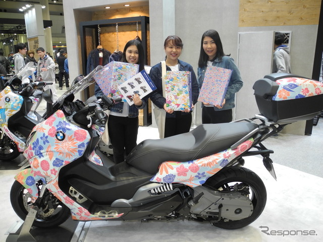 BMWの大型スクーターをラッピングデザインした昭和女子大学の学生。左から室永夏奈さん、内藤彩さん、田中理央さん