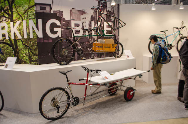 東京サイクルデザイン専門学校の展示に足を止める人（サイクルモード14）