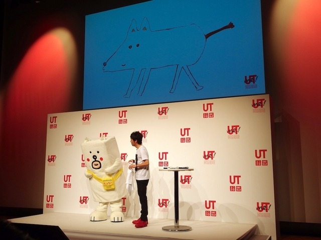 記者会見のゲストは田辺誠一作イラスト「かっこいい犬。」のもっちー（向かって左）と陣内。画面は陣内がTシャツにデザインした犬の原画
