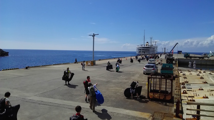 伊豆大島の元町港で大型客船に輪行袋で乗り込むサイクリストたち