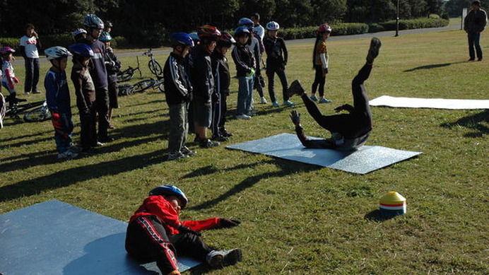 　東京都自転車競技連盟が主催する自転車学校MTB編「うまく転がって、緊張しなければ大丈夫」が12月4日に千葉県の幕張海浜公園MTBコースで行われた。晴天に恵まれた会場には、29人の子供たちと保護者が集まり、元五輪選手のインストラクター竹谷賢二の指導で上手な転び