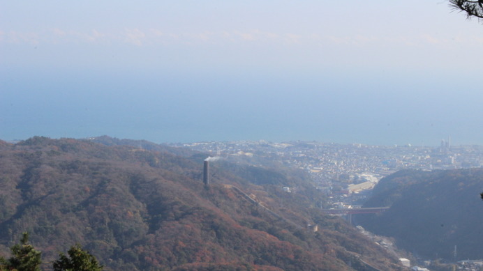 神峰山の頂上からの景色。日立の海や町とともに、日立の大煙突の姿が見える。